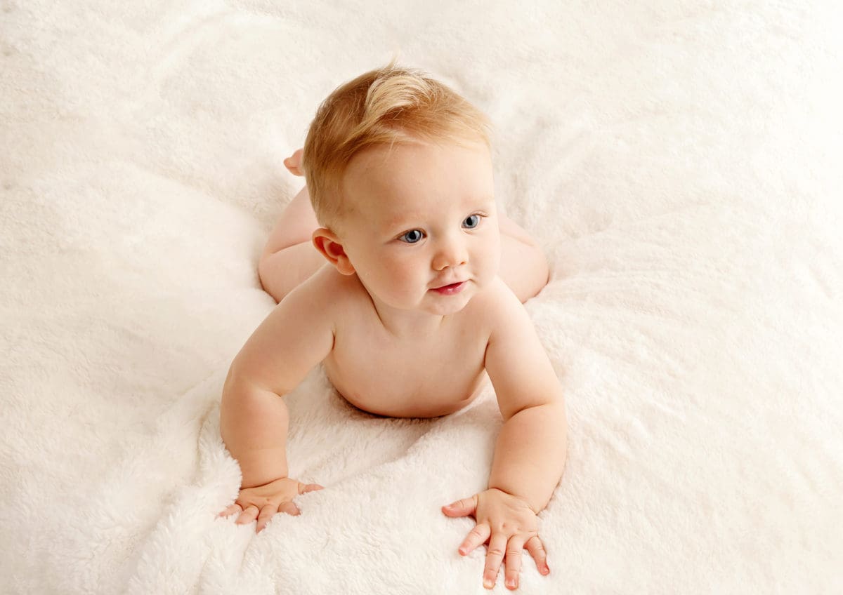 Colour photographic portrait from baby photo session of baby doing tummy time