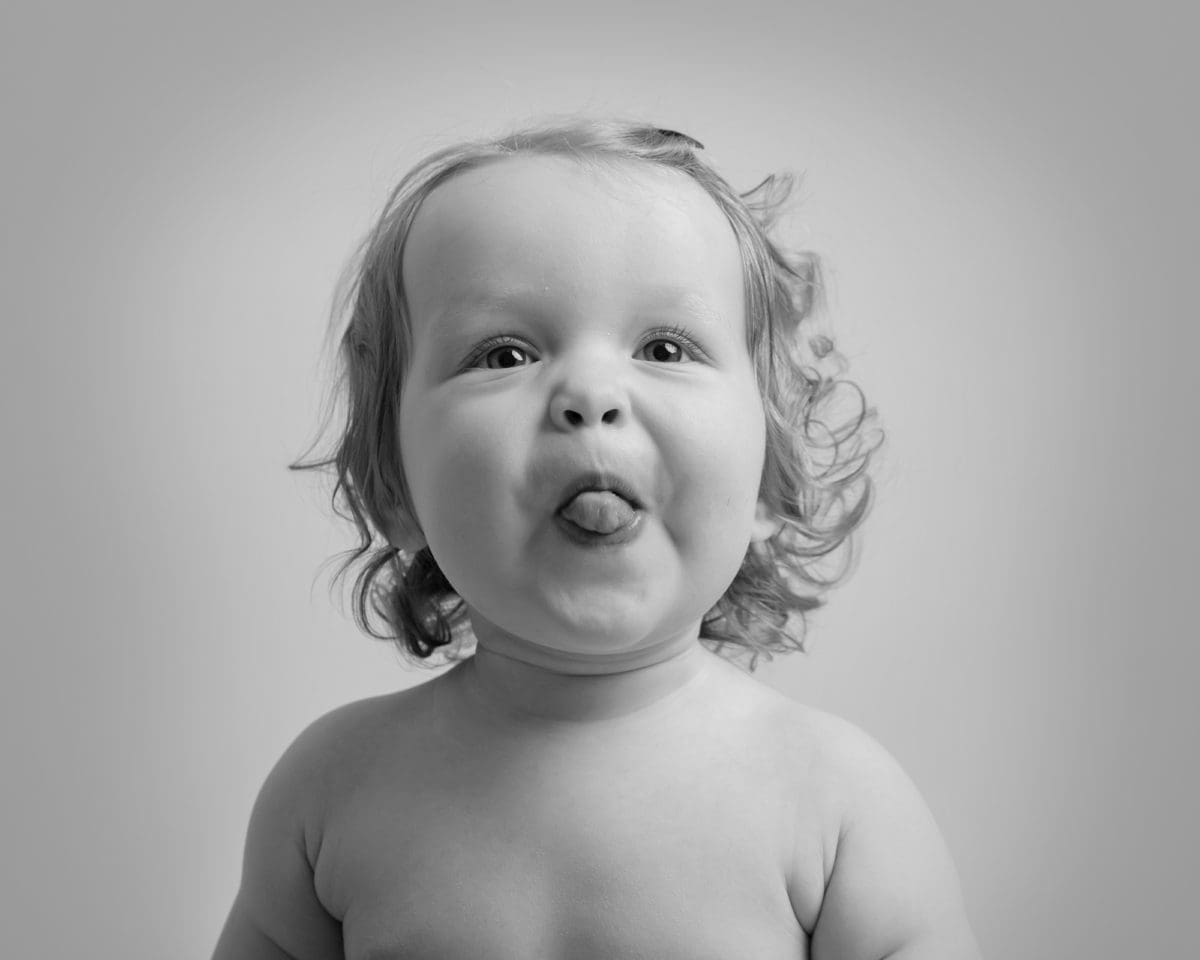 Cheeky baby portrait photography with baby sticking put their tongue