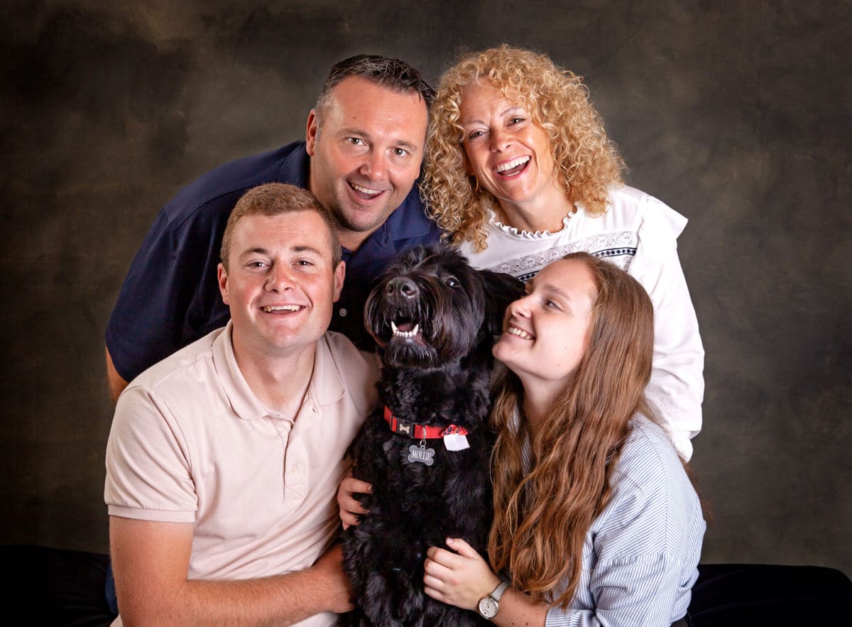 Smiling informal group photo of a family with their dog